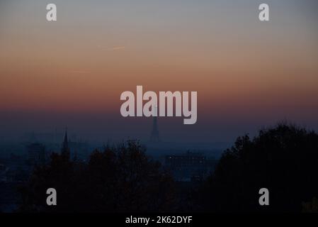 Blick auf die Pariser Stadtlandschaft mit Eiffelturm und Kirchen Silhouetten bei Sonnenuntergang vom Belleville Park. Paris, Frankreich. Stockfoto