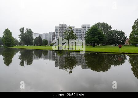 Kortrijk, Westflandern Region - Belgien - 07 10 2021 der Stadtpark Raemdonck Wasserteich mit Wohnblocks, die sich im Hintergrund spiegeln Stockfoto