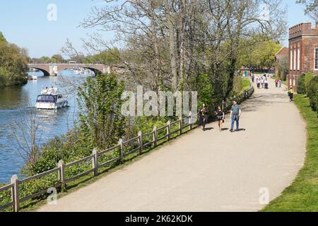 Menschen, die den sonnigen Frühlingstag auf dem Thames Path in Hampton, Richmond upon Thames, London, England, Großbritannien genießen Stockfoto