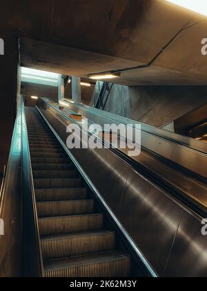 Eine vertikale Aufnahme einer leeren Rolltreppe in der Nacht im Bahnhof Stockfoto