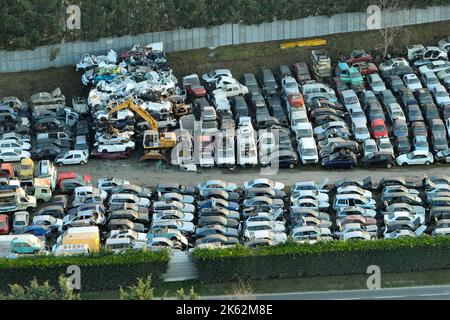 Luftaufnahme des großen Parkplatzes von Schrottplatz mit Reihen von weggeworfenen gebrochenen Autos. Recycling von Altfahrzeugen Stockfoto