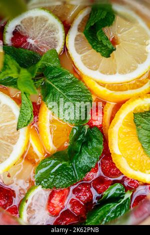 Erfrischende Limonade mit frischen Orangenkirschen und Minzblättern. Köstlicher alkoholfreier Fruchtcocktail in einem Krug Stockfoto