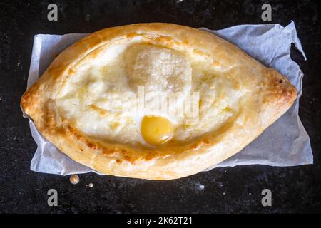 Adjarian chatschapuri auf einem Backblech. Traditionelles georgisches Gericht mit Käse und Hühnereier. Stockfoto