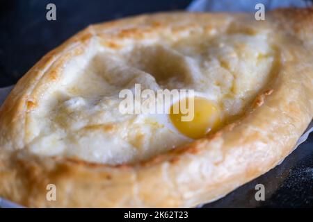 Adjarian chatschapuri auf einem Backblech. Traditionelles georgisches Gericht mit Käse und Hühnereier. Stockfoto