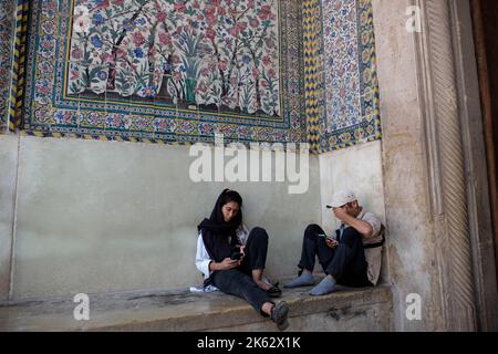 Shiraz, Fars, Iran. 9. Oktober 2022. Eine iranische Frau sitzt in der Nähe einer Moschee in Shiraz, Provinz Fars, Iran, 09. Oktober 2022. Nach dem Tod von Masha Amini, einem 22-jährigen Mädchen, wurde der Iran am 13. September von der Polizeieinheit, die für die Durchsetzung der strengen iranischen Kleiderordnung für Frauen verantwortlich ist, mit weltweiten regierungsfeindlichen Protesten konfrontiert. Amini wurde am 16. September für tot erklärt, nachdem sie 3 Tage im Koma verbracht hatte. Die iranischen Führer verurteilten die Proteste als „Unruhen“ und beschuldigten die USA und Israel, die Proteste im Land geplant zu haben. (Bild: © Rouzbeh Fouladi via ZUMA Press Wire) Stockfoto