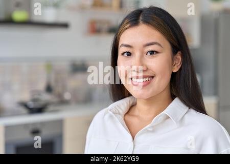 Nahaufnahme Porträt Asian Frau Blick auf Kamera über Home-Office-Innenraum Stockfoto