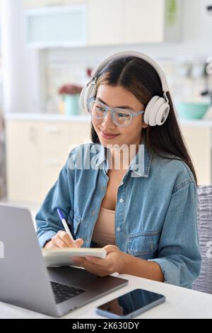Junger asiatischer Student, der online studiert, sieht sich das Webinar zum Thema Bildung auf einem Laptop an Stockfoto