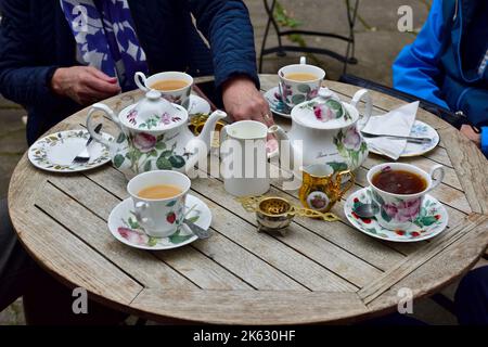 Der traditionelle Teeservice wird auf einem Tisch im Freien in der historischen mittelalterlichen Stadt Warwick, Großbritannien, serviert Stockfoto