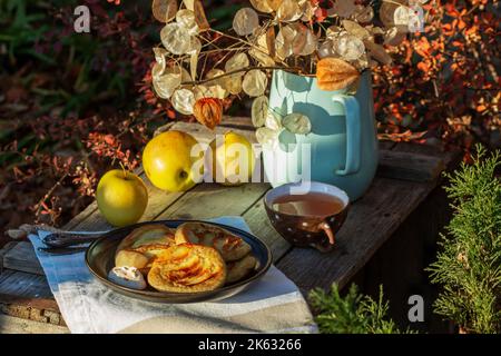 Pfannkuchen mit Vollkornbrot, serviert mit Tee im Garten. Rustikaler Stil. Stockfoto