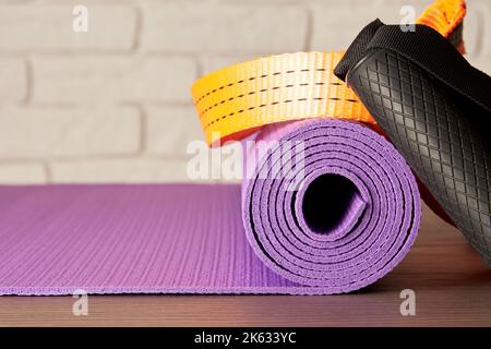 Yogamatte, Griffe und Seile auf dem Boden im modernen Fitnessstudio. Sport- und Fitnessgeräte und Hintergründe Stockfoto