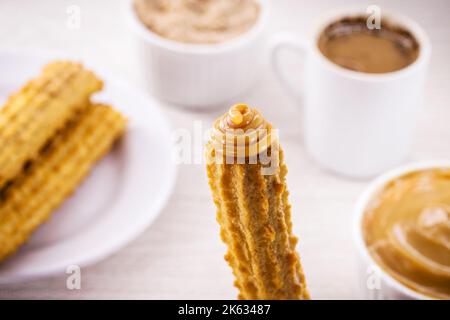 Churros, typisch frittierte Süßigkeit aus Brasilien, Mexiko und Spanien. Bestreut mit einer Schicht Zucker oder Zimt, gefüllt mit Schokolade oder Dulce de leche Stockfoto