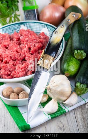 Frische Zutaten zum Kochen gefüllter Zucchini mit Rindfleisch auf dem Küchentisch Stockfoto