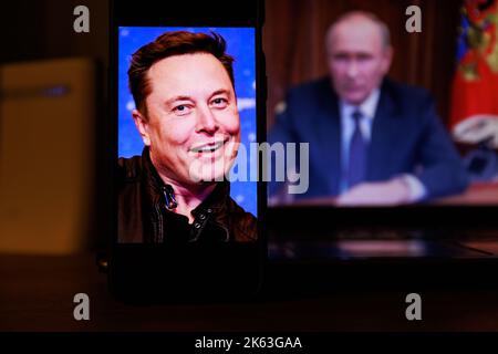 Vilnius, Litauen - 2022. Oktober 11: Elon Musk auf der Leinwand und Wladimir Putin im Hintergrund Stockfoto