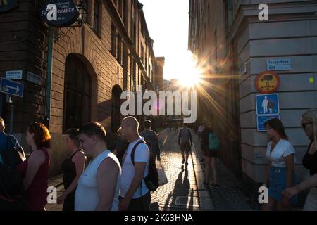 Fußgänger, die bei Sonnenuntergang, Sommerabend, durch die Altstadt Stockhom (Gamla Stan) laufen Stockfoto