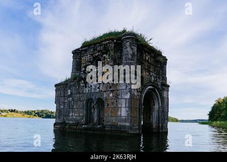Alte überflutete ruinierte verlassene Kirche. Uralte Ruinen auf dem Wasser Stockfoto