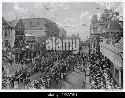 In der Adderley Street versammeln sich die Menschenmassen, um die vorbeiziehende Hauptstraße zu beobachten, während British Union Jack stolz von den Gebäuden aus fliegt. Stockfoto