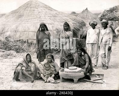 Vintage-Foto aus dem 19.. Jahrhundert: Frauen mit Bheel oder Bhil mahlen Mais, Indien Stockfoto