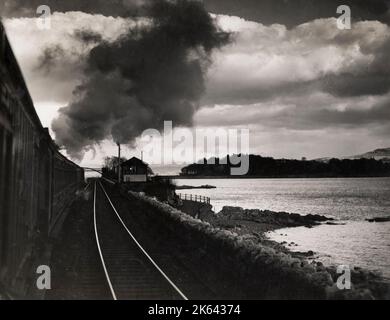 Vintage-Fotografie des frühen 20. Jahrhunderts - Dampfzug, der gegen den Himmel ragte, der die Ostküste Englands hinauf fuhr Stockfoto