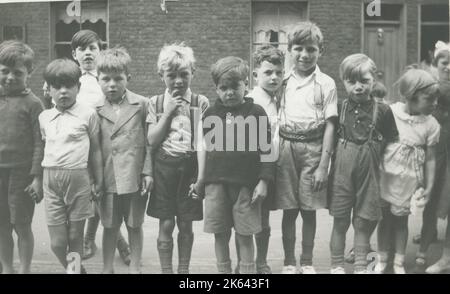 Eine Gruppe von Kindern stellte sich für ein Foto in einer terrassenförmigen Straße auf. Stockfoto