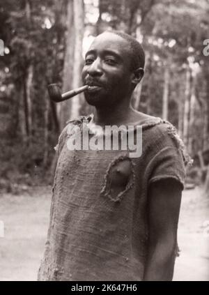 1940s Ostafrika Uganda - Budongo-Wald, Fällen und Sägen von Mahagonibäumen - ein Holzfäller mit seinem Rohrfoto eines während des Zweiten Weltkriegs in Ostafrika und im Nahen Osten stationierten britischen Armeeanwärters Stockfoto