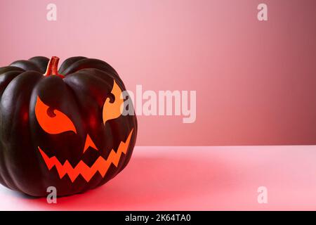 Halloween Kürbis mit papiergeschnittenem, unerschrossenem Gesicht in trendig roter Farbe. Jack Halloween. Lächle Jack Pumpkin Stockfoto