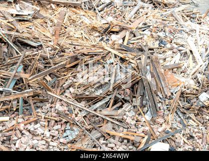 Nahaufnahme eines großen Schutthaufens und Schutthauses aus einem abgerissenen Gebäude. Der Stapel besteht aus Holz, Ziegel, Gips usw. Stockfoto