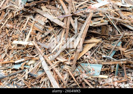 Nahaufnahme eines großen Schutthaufens und Schutthauses aus einem abgerissenen Gebäude. Der Stapel besteht aus Holz, Ziegel, Gips usw. Stockfoto