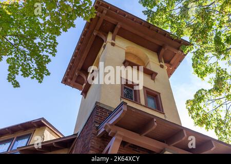 Blick nach oben auf einen Kirchturm im spanischen Stil des frühen 20.. Jahrhunderts und einen Glockenturm mit Stuckwand und Bogenfenstern Stockfoto