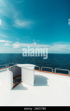 Eine vertikale Weitwinkelaufnahme einer hellen Tauchsafari-Yacht auf dem Oberdeck mit einem selektiven Fokus auf der Leiter, die unten zum Mitteldeck führt; dem oc Stockfoto