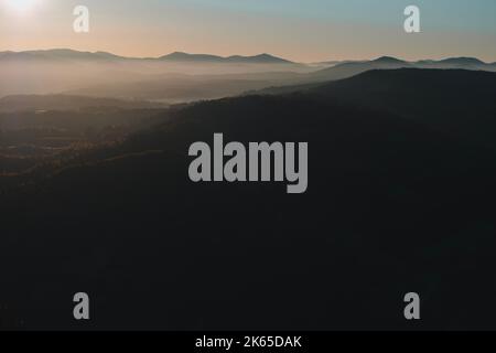 Wunderschöne Aussicht auf die Berge am Morgen. Herbst neblige Landschaft Stockfoto