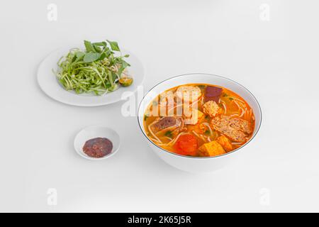 Bun Rieu Cua, Krabbenpaste Vermicelli-Suppe mit gehackten Garnelen, Tofu, Tomaten, Garnelenpaste, vietnamesisches Essen auf weißem Hintergrund isoliert; Perspektive vie Stockfoto