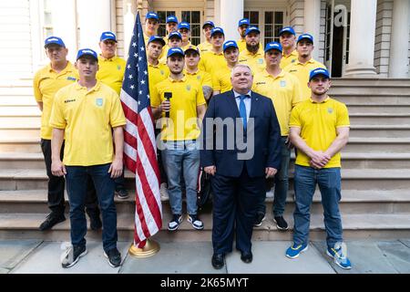 New York, USA. 12. Oktober 2022. Das ukrainische nationale Baseballteam, Bürgermeister Eric Adams, und Beamte der FDNY und der NYPD posieren auf den Stufen des Rathauses. Die ukrainische nationale Baseballmannschaft wird Charity-Spiele gegen die NYPD und FDNY spielen. Zu ihnen kamen die amtierende Kommissarin der FDNY, Laura Cavanaugh, der Abteilungsleiter der FDNY, John Hodgens, der operative Leiter der FDNY, James Esposito, der erste stellvertretende Kommissar der NYPD, Edward Caban, der ukrainische Generalkonsul Oleksii Holubow und der Kommissar für internationale Angelegenheiten, Edward Mermelstein. (Foto von Lev Radin/Pacific Press) Quelle: Pacific Press Media Pro Stockfoto