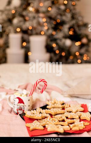 Weihnachtskekse mit Weihnachtsschmuck auf dem Bett im Innenraum Stockfoto