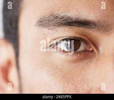 Nahaufnahme eines Mannes mit gemischter Rasse, der im Studio ernst aussieht. Asiatischer Mann, der in Innenräumen ohne Ausdruck und Copyspace steht. Bereit, den Optiker zu sehen Stockfoto