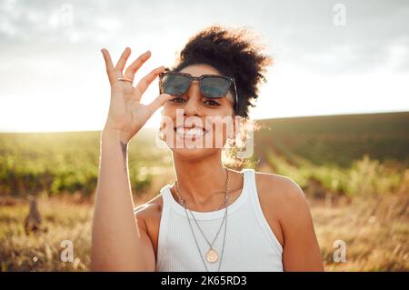 Junge schwarze Frau, Sonnenuntergangsporträt auf dem Felde und glückliches Lächeln mit Sommersonnenbrille in Brasilien. Outdoor-Abenteuer in der Natur, Reisefreiheit Stockfoto