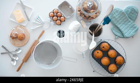 Verschiedene Backwaren auf der Küchentheke von oben. Backutensilien auf einem Küchentisch. Stillleben von Speisen und Zutaten auf dem Tisch Stockfoto