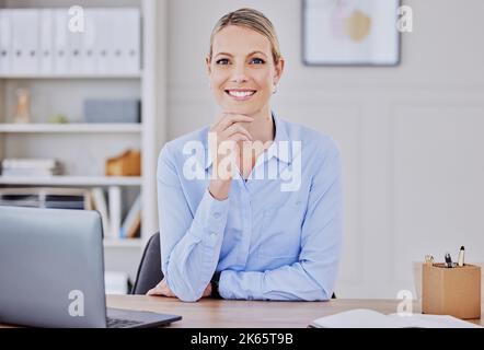 Porträt einer schönen jungen kaukasischen Geschäftsfrau, die bei der Arbeit an ihrem Laptop im Büro arbeitet. Selbstbewusste und erfolgreiche Unternehmerin Stockfoto