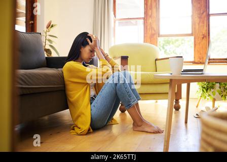 Gestresste Frau, Depression und einsam im Wohnzimmer sitzen auf dem Boden zu Hause. Junge traurige Frau, die an psychischen Problemen leidet und Stockfoto