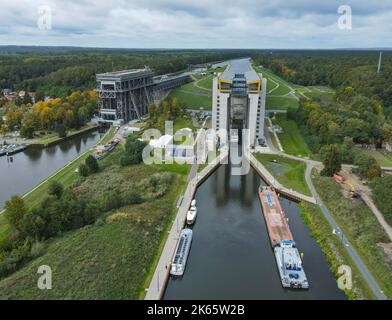 Niederfinow, Deutschland. 04. Oktober 2022. Der alte (l) und der neue (r) Schiffslift (Luftaufnahme mit Drohne). Am selben Tag wurde der neue Schiffshebewerkstand feierlich eröffnet. Die Dimensionen des neuen Schiffshebezugs sind enorm. Der Trog, in dem die Schiffe die rund 36 Meter im Aufzug hinauf- oder hinabfahren können, wiegt 9800 Tonnen. Die Wasser- und Schifffahrtsverwaltung des Bundes hat rund 520 Millionen Euro in den neuen Aufzug investiert. Die alte Schiffshebewere stammt aus dem Jahr 1934 und ist noch in Betrieb. Quelle: Patrick Pleul/dpa/Alamy Live News Stockfoto