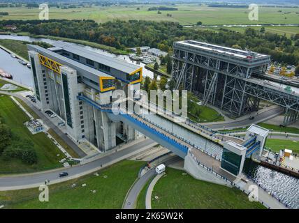 Niederfinow, Deutschland. 04. Oktober 2022. Der alte (r) und der neue (l) Schiffslift (Luftaufnahme mit Drohne). Am selben Tag wurde der neue Schiffshebewerkstand feierlich eröffnet. Die Dimensionen des neuen Schiffshebezugs sind enorm. Der Trog, in dem die Schiffe die rund 36 Meter im Aufzug hinauf- oder hinabfahren können, wiegt 9800 Tonnen. Die Wasser- und Schifffahrtsverwaltung des Bundes hat rund 520 Millionen Euro in den neuen Aufzug investiert. Die alte Schiffshebewere stammt aus dem Jahr 1934 und ist noch in Betrieb. Quelle: Patrick Pleul/dpa/Alamy Live News Stockfoto