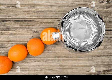 Draufsicht auf Orangen, die auf einem elektrischen Zitruspresse gepresst werden Stockfoto