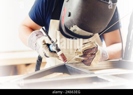 Männliche in Gesichtsmaske Schweißnähte mit Argon - Lichtbogenschweißen Stockfoto