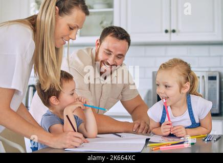 Kaukasische Eltern helfen Kindern mit Hausaufgaben. Glückliche Geschwister, die Schularbeiten machen. Mutter hilft ihrem Sohn bei den Hausaufgaben.Bruder und Schwester zeichnen Stockfoto