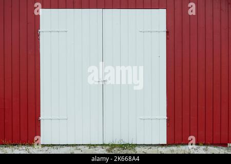 Rote Tür und Außenwand mit Klapptafel - Stock Photo Stockfoto