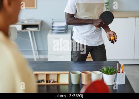 Nahaufnahme von zwei jungen Leuten, die im Pausenraum im Büro Tischtennis spielen, Kopierfläche Stockfoto