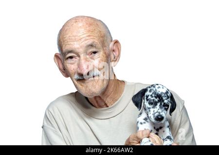 Hispanischer Senior-Mann mit dalmatinischem Hundewelpen Stockfoto