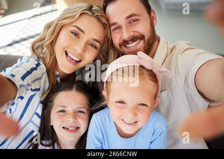 Nahaufnahme einer glücklichen kaukasischen Familie, die zu Hause Selfies macht. Liebevolle Eltern, die Fotos und Bilder für besondere Kindheitserinnerungen während der Bindung aufnehmen Stockfoto