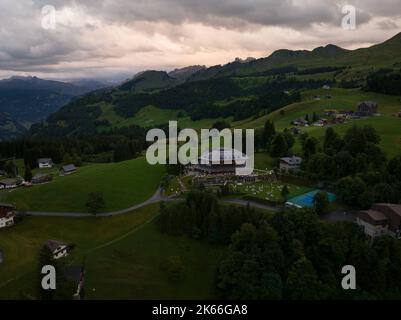 Schweizer Bergdorf Stoos bei Sonnenuntergang Drohnenübersicht im Kanton Schwyz. Wanderdorf in der Nähe von Fronalpstock Ridge Wanderung. Resort und Wandern Stockfoto