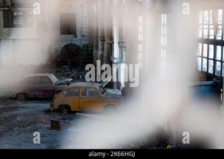 Alte, vergessene Autos in einer verlassenen Garage. Foto aufgenommen unter Tageslicht. Stockfoto