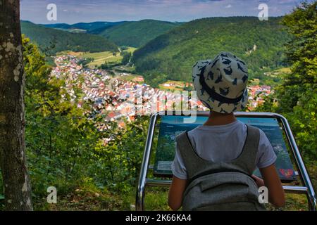 Kleiner Junge, der auf einem Hügel steht und auf eine farbenfrohe hügelige Sommerlandschaft in der Schwäbischen Alb herabblickt Stockfoto